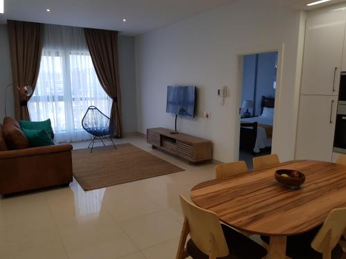 a living room with a wooden table and a dining room at Apartments at Itowers, CBD, Gaborone in Gaborone