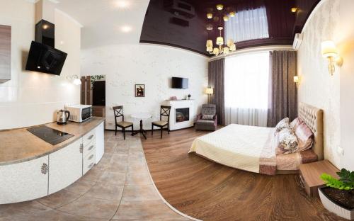 ein Schlafzimmer mit einem Bett, eine Küche und ein Wohnzimmer in der Unterkunft Studio on Rymarskaya in Kharkov