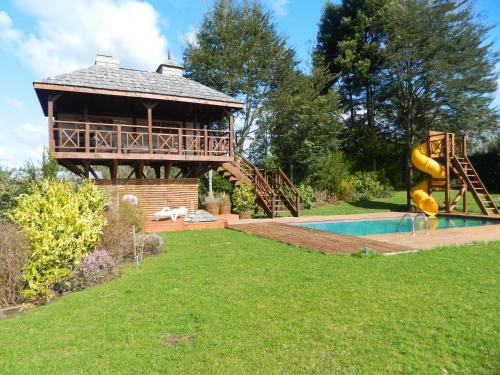 a house with a slide next to a pool at Cabañas Lomas del Lago in Frutillar