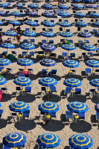 a group of blue chairs and umbrellas on a beach at Hotel Mara in Ortona