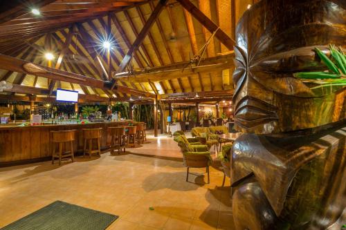 a bar with a statue in the middle of a room at Sanctuary Rarotonga on the Beach (Adults Only) in Rarotonga