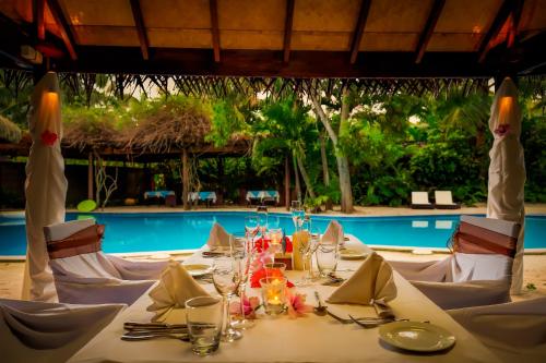 a table set for a meal in front of a pool at Sanctuary Rarotonga on the Beach (Adults Only) in Rarotonga