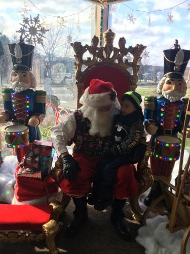 a young girl is sitting on a santa claus chair at Lull-Abi Inn in Egg Harbor