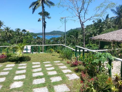a garden with a view of the ocean at Dahilig Resort in Puerto Galera