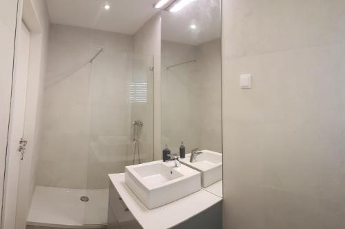 a white bathroom with a sink and a shower at Casa da Prelada in Amarante