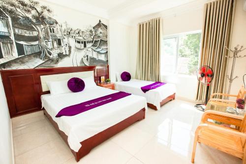 a bedroom with two beds and a painting on the wall at Dang Quang Guesthouse in Ha Long