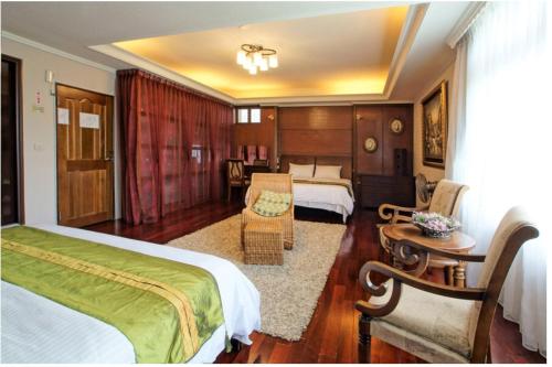 a hotel room with two beds and a couch at Emaly Homestay in Taitung City