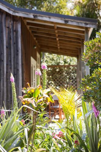 a wooden pergola in a garden with plants at The Church Accommodation in Hahei