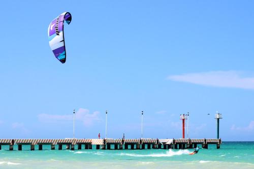 a person flying a kite over a pier in the ocean at Hotel La Casa Cielo solo adultos in El Cuyo