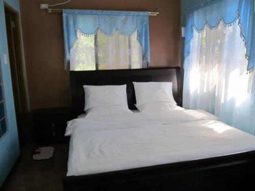 a bed with white sheets and pillows in a bedroom at Ucoy Beach Resort in Libertad