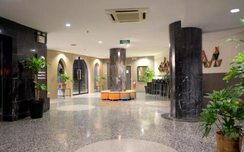 a lobby with pillars and potted plants in a building at I Pavilion Hotel Phuket in Phuket Town