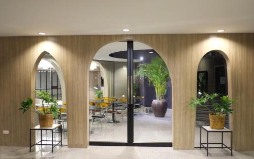 プーケットタウンにあるI Pavilion Hotel Phuketのアーチのあるロビーと鉢植えのテーブル