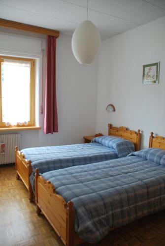 a bedroom with two beds and a window at Appartamento Giuliana in Sappada