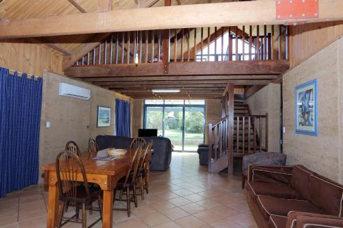 a dining room with a wooden table and chairs at Margaret River Seascape in Margaret River Town