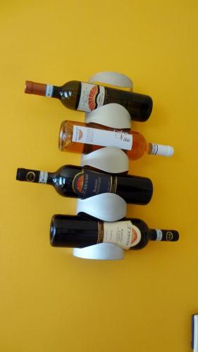 a group of bottles of wine on a yellow wall at La trifula bianca apts. in Alba