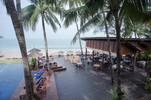 a resort with chairs and tables and palm trees at Amata Resort & Spa, Ngapali Beach in Ngapali