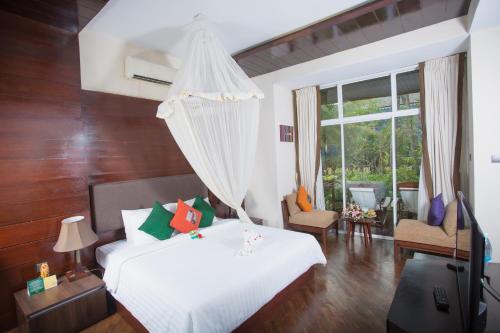 a bedroom with a white bed and a window at Amata Resort & Spa, Ngapali Beach in Ngapali