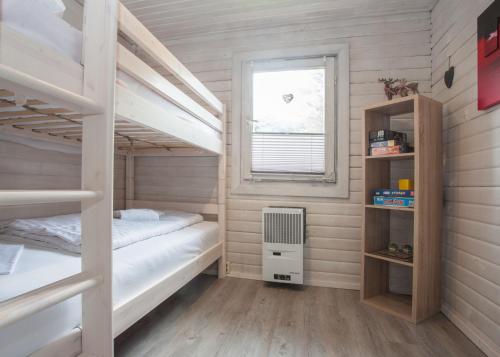 1 Schlafzimmer mit 2 Etagenbetten und einem Fenster in der Unterkunft Ferienhaus Auf der Heide 26-S, Winterberg-Niedersfeld in Winterberg