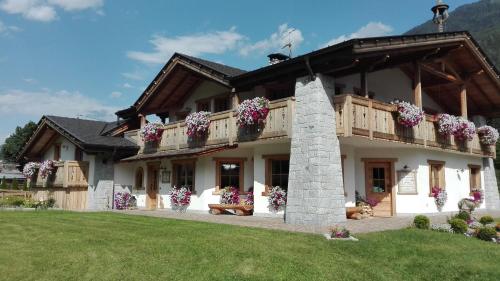 a large house with flowers on the balcony at Agriturismo Maso Grisun in Borzago
