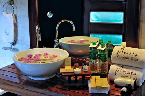 a bathroom with two sinks and two bowls at Amata Resort & Spa, Ngapali Beach in Ngapali