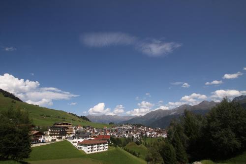 a view of a town on a hill with mountains at Hotel Bärolina in Serfaus