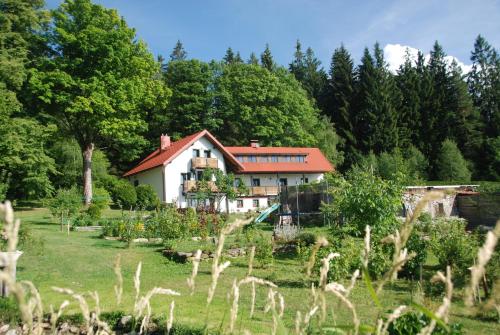 ein Haus inmitten eines Gartens in der Unterkunft Penzion Nadějov in Kašperské Hory