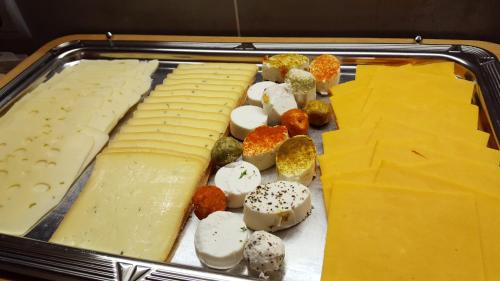 ein Tablett mit verschiedenen Käsesorten und anderen Lebensmitteln in der Unterkunft Pension Mirabelle in Ellmau