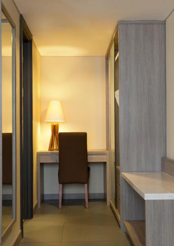 a desk with a chair in a hotel room at BW Kemayoran Hotel & Convention Powered by Archipelago in Jakarta