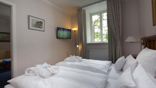 two beds in a hotel room with white sheets at Hotel Badehaus Goor in Putbus