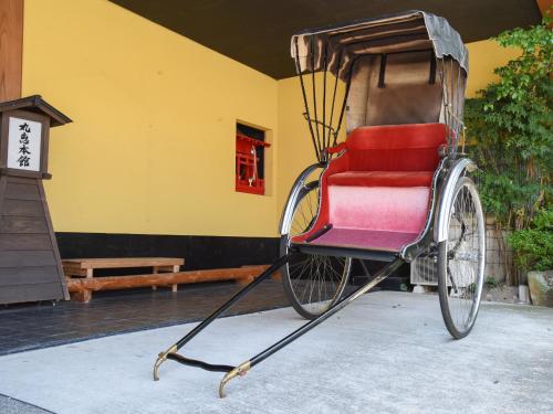 a rickshaw parked in front of a building at Ryokan Marue Honkan in Hitoyoshi
