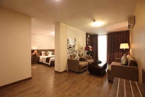 ein Wohnzimmer mit einem Sofa und einem Bett in einem Zimmer in der Unterkunft Minh Tam Hotel & Spa 3/2 in Ho-Chi-Minh-Stadt