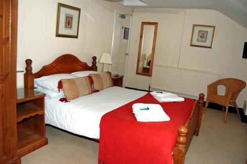 a bedroom with a bed with a red blanket at Old Post Office in Shrewsbury