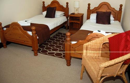 um quarto de hotel com duas camas e duas cadeiras em Old Post Office em Shrewsbury