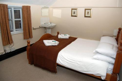 a bedroom with a bed with two towels on it at Old Post Office in Shrewsbury