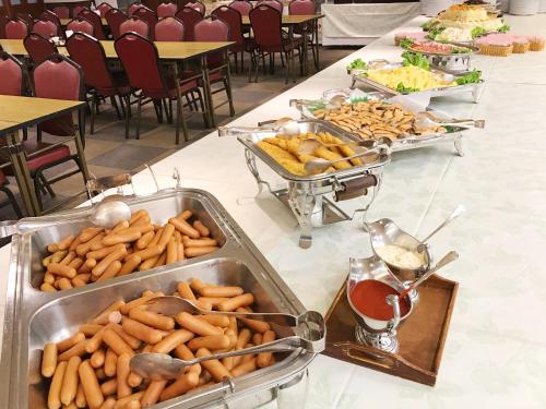 a buffet line with trays of food on a table at Osaka Academia in Osaka