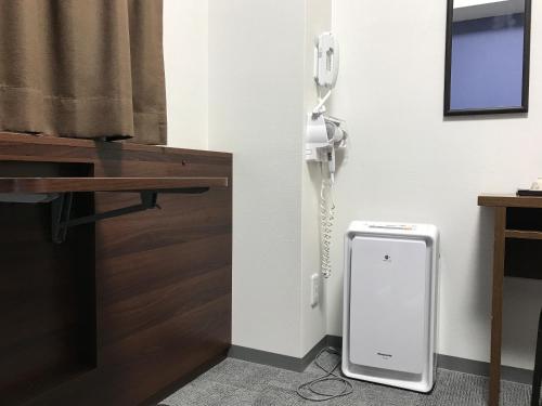 a room with a phone on the wall next to a desk at Osaka Academia in Osaka