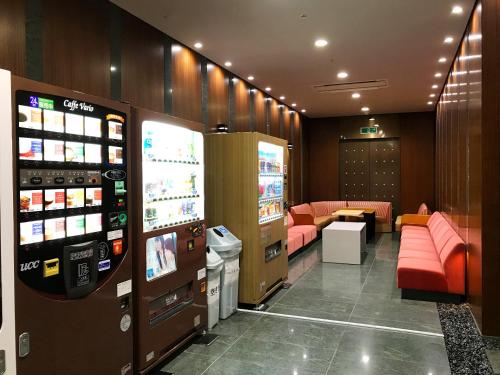 a room with a video game machine and a couch at Osaka Academia in Osaka