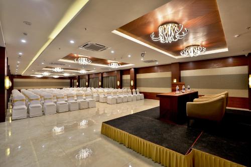 a banquet hall with white chairs and a podium at VITS Devbhumi, Dwarka in Dwarka