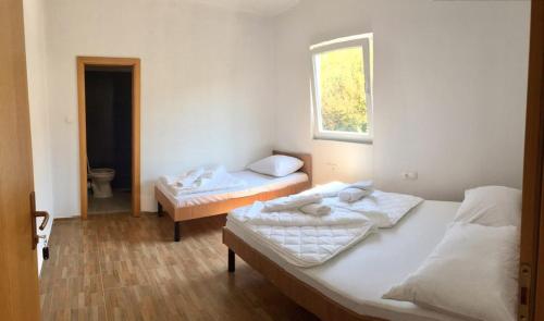 a bedroom with two beds and a window at Guesthouse Soče in Međugorje
