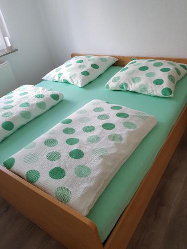 two twin beds with green and white sheets and pillows at Schöne, private Wohnungen in Aalen