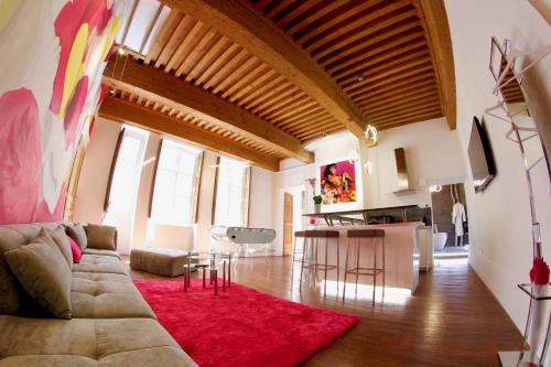 a living room with a couch and a red rug at le XVI de la Rose in Lyon