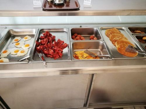a buffet line with eggs and other breakfast foods at Patmos Paradise Hotel in Kámbos