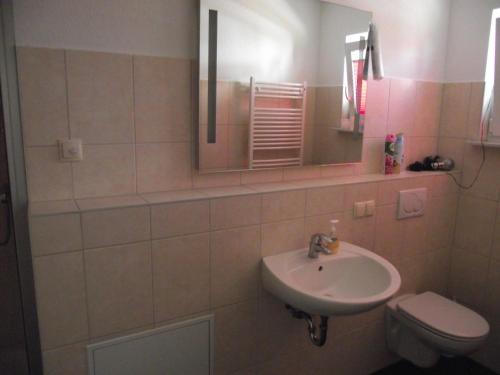 Un baño con lavabo, inodoro y espejo. en Ferienwohnung relax, en Ostseebad Koserow