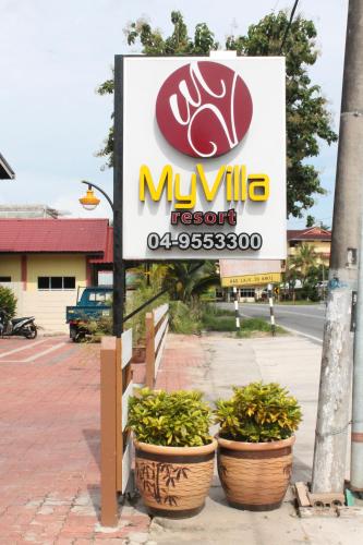 a sign for a miuille resort with three plants at Myvilla Langkawi Hotel in Pantai Cenang
