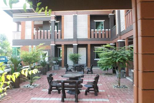 a patio with tables and chairs in front of a building at Myvilla Langkawi Hotel in Pantai Cenang