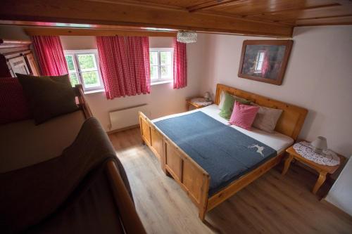 a bedroom with a large bed with a blue blanket at Achentaler Bauernhäusl in Achenkirch