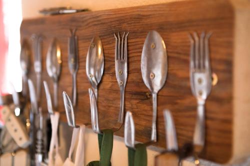 a bunch of utensils hanging on a wall at Achentaler Bauernhäusl in Achenkirch