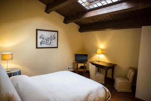 a bedroom with a bed and a desk and a television at B&B Charme Celestino V° in LʼAquila