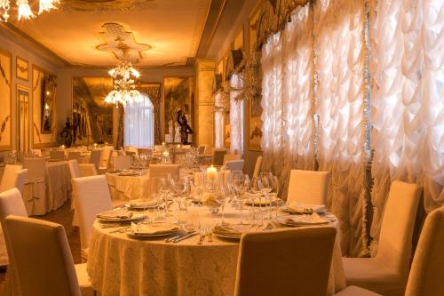 a dining room with white tables and white chairs at Castello Di Spessa - Residenze d'epoca in Capriva del Friuli