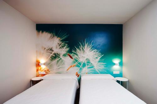 ビトリア・ガステイスにあるApartamentos Divanの壁に絵が飾られた部屋にベッドが2つある